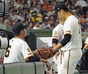 5回を投げ終え、坂本(左)に迎えられる巨人・田中将=東京ドーム