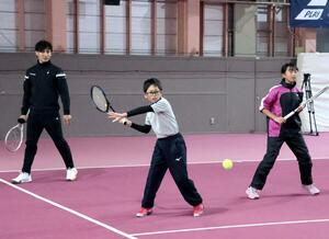 子どもたちに技術指導するプロテニス選手の島袋将さん（左）＝上越市中田原