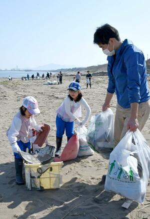 浜辺のごみなどを拾い集める参加者=上越市五智5