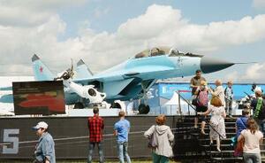 モスクワ郊外の飛行場で開催中の国際航空見本市「MAKS2017」で、ロシアの最新鋭戦闘機ミグ35を見学する人たち=2017年7月(共同)