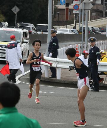 日大の８区鈴木孔士（左・中越高出）がたすきを渡す＝２０２４年１月３日、横浜市