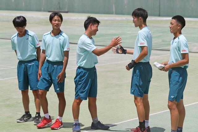 県高校総体テニス男子団体決勝を制して１１連覇を決め喜ぶ東京学館の選手たち＝６月７日、南魚沼市大原運動公園