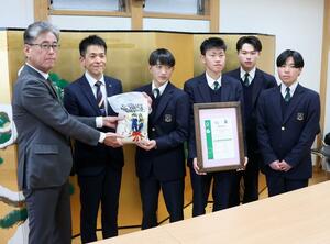 富寿しに栽培したコメを手渡す高田農業高の生徒ら=上越市南本町3