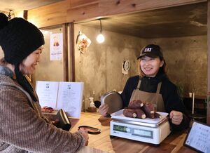 「焼き芋専門店 みつみつ」でお客さんとやり取りをする滝沢真夏さん=魚沼市下田