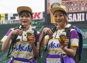 限定販売する生ビール「アサヒクラシック」の発表会で、記念撮影に応じる販売員=4月8日、阪神甲子園球場