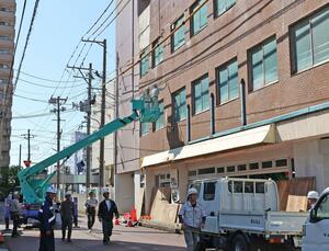外壁の一部が落下し、補修作業が行われる「ショップイン大手」＝１３日、長岡市