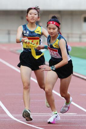 県中学駅伝女子 2位の弥彦JHSRC 4区幸田みなみ(左)が5区相沢茉胡(右)にタスキを渡す=11月8日、デンカビッグスワン