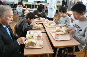 甘エビカレーなどをおいしそうに食べる児童と米田徹市長(左)=糸魚川市の大和川小