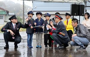 駅員なりきりコンテストで車掌のものまねをする子どもたち=11月2日、上越市中郷区の二本木駅前広場