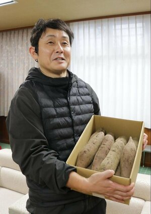 収穫したサツマイモを紹介する西村組の西村裕之社長＝加茂市役所