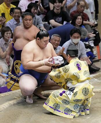 豊昇龍を破り、懸賞を受け取る大の里＝両国国技館