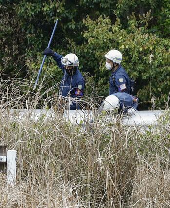 前日にスニーカーが発見された山中付近を捜索する京都府警の捜査員＝１３日午後１時９分、京都府南丹市