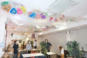 障害者らが思い思いにデザインした透明傘が並ぶ展示会=長岡市来迎寺