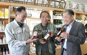 共同で開発したコーヒーリキュール「ＡＭＡＲＥＬＯ（アマレロ）」を手にする（左から）竹田成典さん、山倉政美さん、杉田彰さん＝上越市春日新田１のまいどや