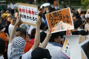 参政党の街頭演説会場で抗議の声を上げる人たち=7月、東京都港区