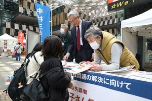 中村三奈子さんの情報提供を求め、署名の協力を呼びかける母クニさん(右)。磯田達伸・長岡市長も参加した=3月24日、長岡市大手通1