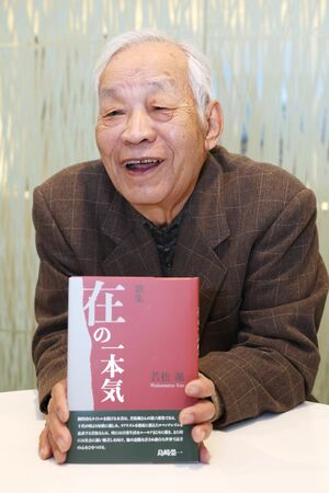 ６冊目の歌集を持ち、制作について語る若松颯さん＝長岡市千歳１