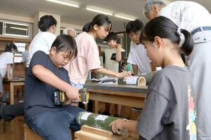 町特産の竹で灯籠を作る田上小の6年生=田上町田上