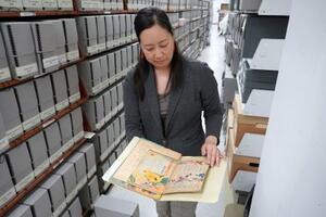米メリーランド大のプランゲ文庫で、GHQ占領下の日本で出版された児童雑誌を手にするジェンキンス加奈さん=5月、ワシントン郊外(共同)