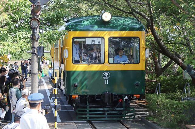 家族連れらを乗せて走る旧新潟交通電車線の「かぼちゃ電車」＝２８日、新潟市南区