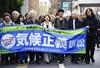 　「気候正義訴訟」との横断幕を掲げ、東京地裁に向かう原告ら＝２０２５年１２月、東京・霞が関