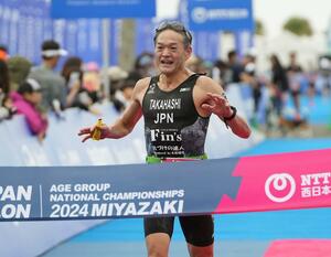 トライアスロン年代別選手権大会最終戦の宮崎大会でゴールする髙橋克哉さん=2024年11月、宮崎市(髙𣘺さん提供)