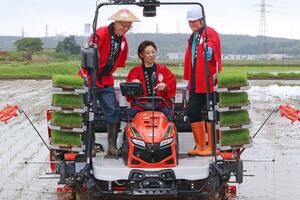 米山プリンセスの田植え。越乃リュウさん(中央)が桜井市長(左)と安野さんと共に田植え機に乗った=5月21日、柏崎市西山町内方