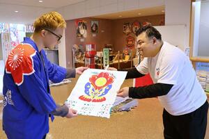 内子町の大角昂平さん（右）から五十崎の技と白根の絵柄で作られたオリジナル凧を受け取る水戸部敬彦さん＝新潟市南区上下諏訪木