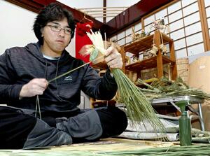 今年の干支「午」のたてがみを作る青野尚登さん。「引っ張りすぎると切れてしまう」と話す＝上越市板倉区