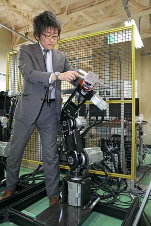 産業用ロボットの調整をする横倉勇希准教授=長岡市上富岡町の長岡技術科学大