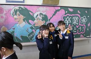 門出を祝う黒板アートの前で笑顔を見せる白山小の卒業生＝１９日、新潟市中央区