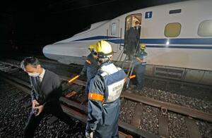 　ＪＲ東海の訓練で、停止した新幹線の車両から線路に降りる乗客役＝２４日未明、静岡市