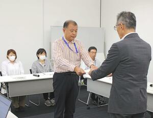 樋口健一教育長(右)に答申書を手渡す検討委の雲尾周委員長=魚沼市役所