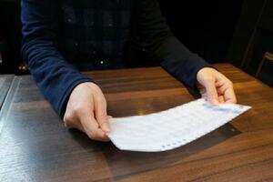 　給与明細を見るビル清掃のパートで働く女性＝１月、東京都千代田区（明細書にぼかし処理をしています）