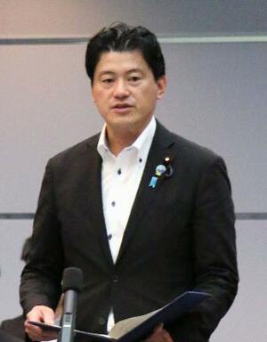 法制審の冒頭、平口法相のあいさつを代読する三谷英弘法務副大臣=15日午前、法務省
