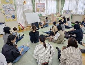 子育て支援施設で人形を使った手遊び歌を歌う親子ら=5月、東京都内