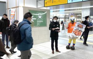 ホーム開幕戦の来場を呼びかけるチラシを配るクラブのスタッフら=2月9日、JR新潟駅