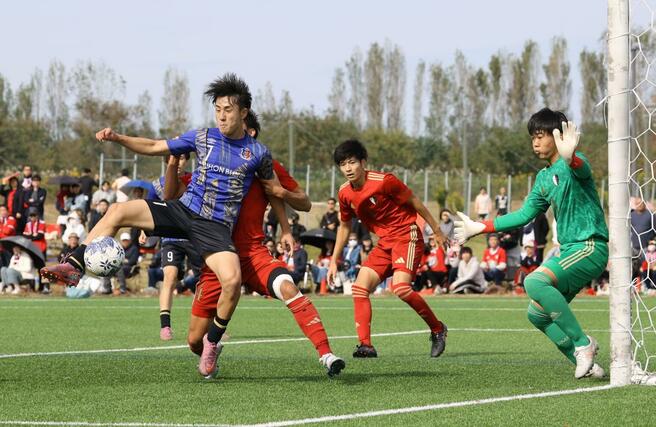 準々決勝　日本文理－新潟明訓　前半、ゴール前で競り合う日本文理のＭＦ行川潮音＝２５日　聖籠町の新潟聖籠スポーツセンター