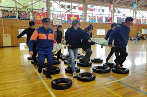 障害物をクリアしながら担架を運ぶ参加者=新発田市藤塚浜