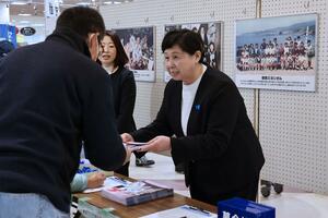 買い物客らに署名の協力を呼びかける曽我ひとみさん=14日、佐渡市