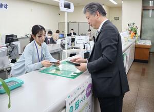 「翠ペイ」の専用アプリに窓口でチャージする平野嘉生・糸魚川信用組合理事長=2月1日、糸魚川市南寺町1