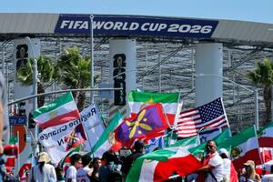 イラン戦の会場前で国旗を手に抗議する人々=15日、ロサンゼルス(ロイター=共同)