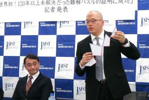 記者会見で裁ち合わせパズルの証明について説明する北陸先端科学技術大学院大の鎌田斗南助教(右)と上原隆平教授=2025年3月、東京都港区