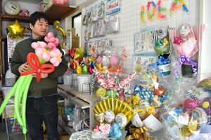 多彩な風船を飾っている「バルーンショップイデア」の店長、星島陽太さん=長岡市千手3