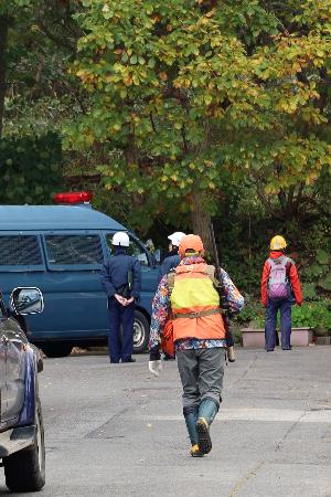 ヒグマ2頭が居座った公園に向かうハンター=23日午前、札幌市西区