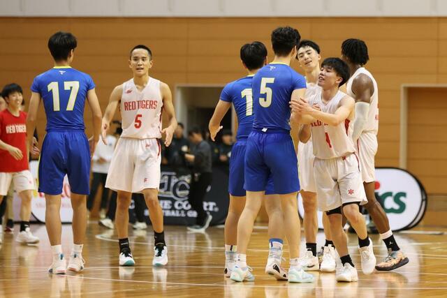 男子決勝リーグ　開志国際－帝京長岡　試合を終え、健闘をたたえ合う両チームの選手たち＝新潟市東総合スポーツセンター