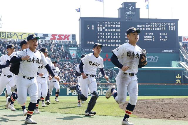 高知農－日本文理　８－１で高知農を破り、１５年ぶりの選抜白星を挙げ、笑顔でベンチに引き上げる日本文理の選手たち＝２１日、阪神甲子園球場