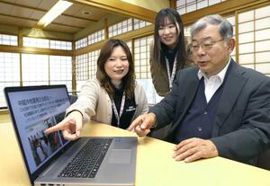 阪神大震災のイベントで活動報告するための資料を見る刈羽村社会福祉協議会の武本純さん(右)と太田美月さん(左)、村田舞佳さん=刈羽村