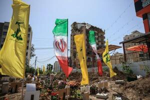 仮設の墓地ではためくヒズボラとイランの旗=16日、レバノン(ロイター=共同)