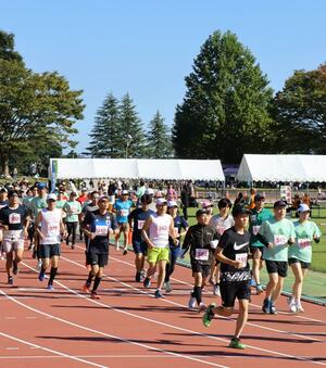 新井総合公園陸上競技場をスタートするランナーたち=13日、妙高市錦町2